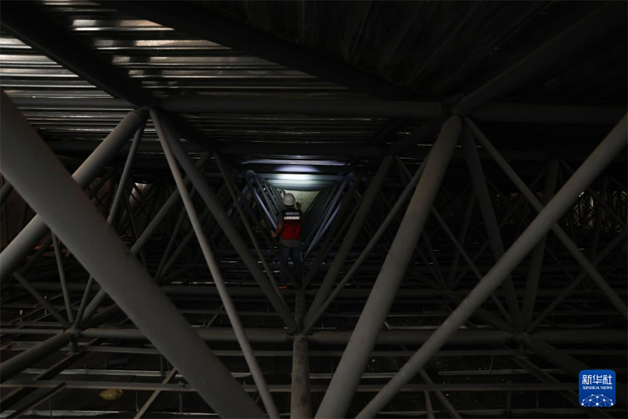 1月1日，在瓦努阿圖維拉港，中國地震局專家組成員在一棟建筑的結構頂部網架位置查看受損情況。新華社記者 龍雷 攝