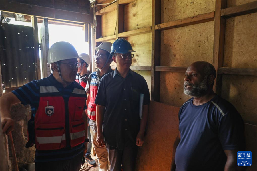 1月1日，在瓦努阿圖維拉港，中國地震局專家組成員向當地居民了解房屋受損情況。新華社記者 龍雷 攝