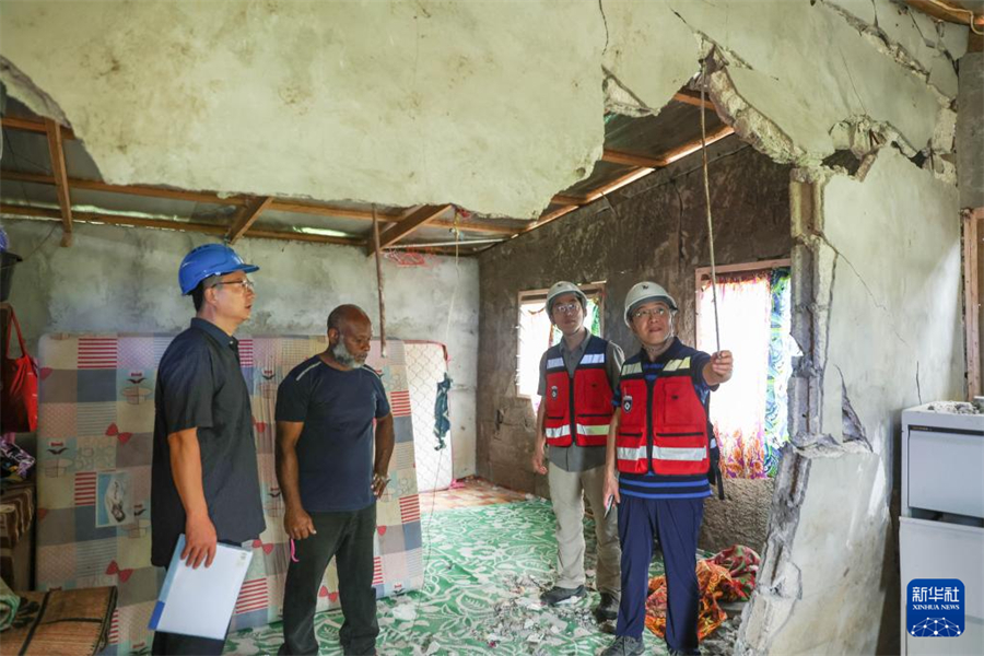 1月1日，在瓦努阿圖維拉港，中國地震局專家組成員在一處房屋內查看受損情況。新華社記者 龍雷 攝