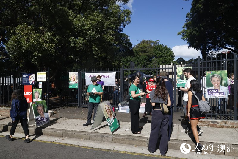 志愿者在投票站外向選民分發宣傳單（攝影 劉美鷺）