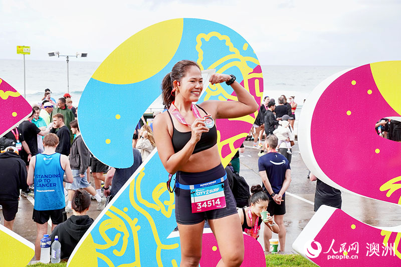 完賽跑者舉起獎牌留影（攝影 陳芃蕾）